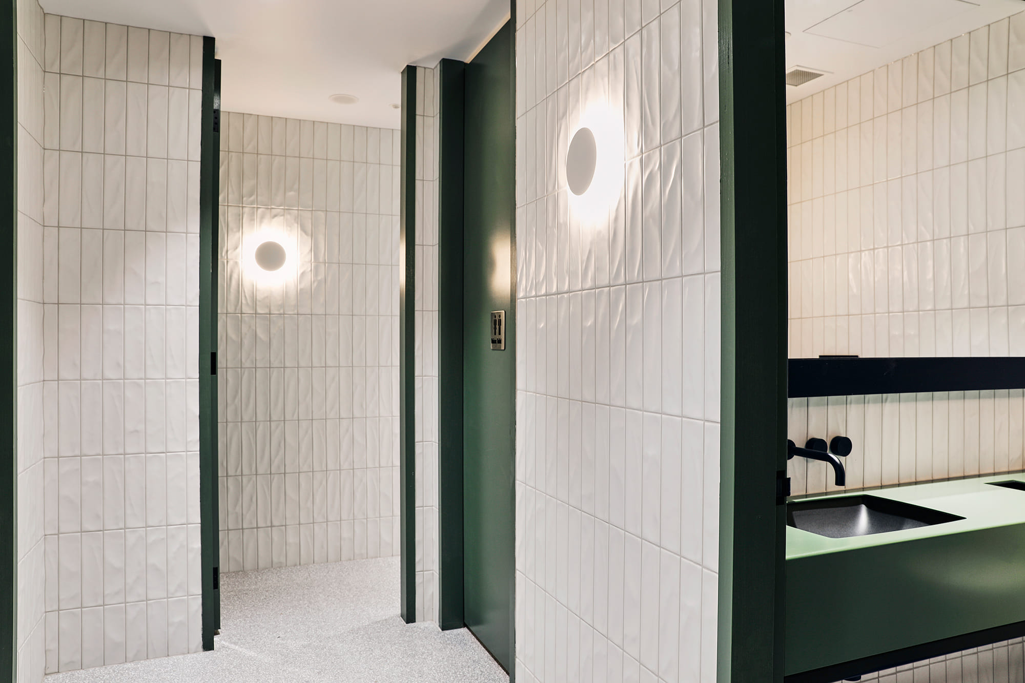 Modern bathrooms with white tiles and green doors