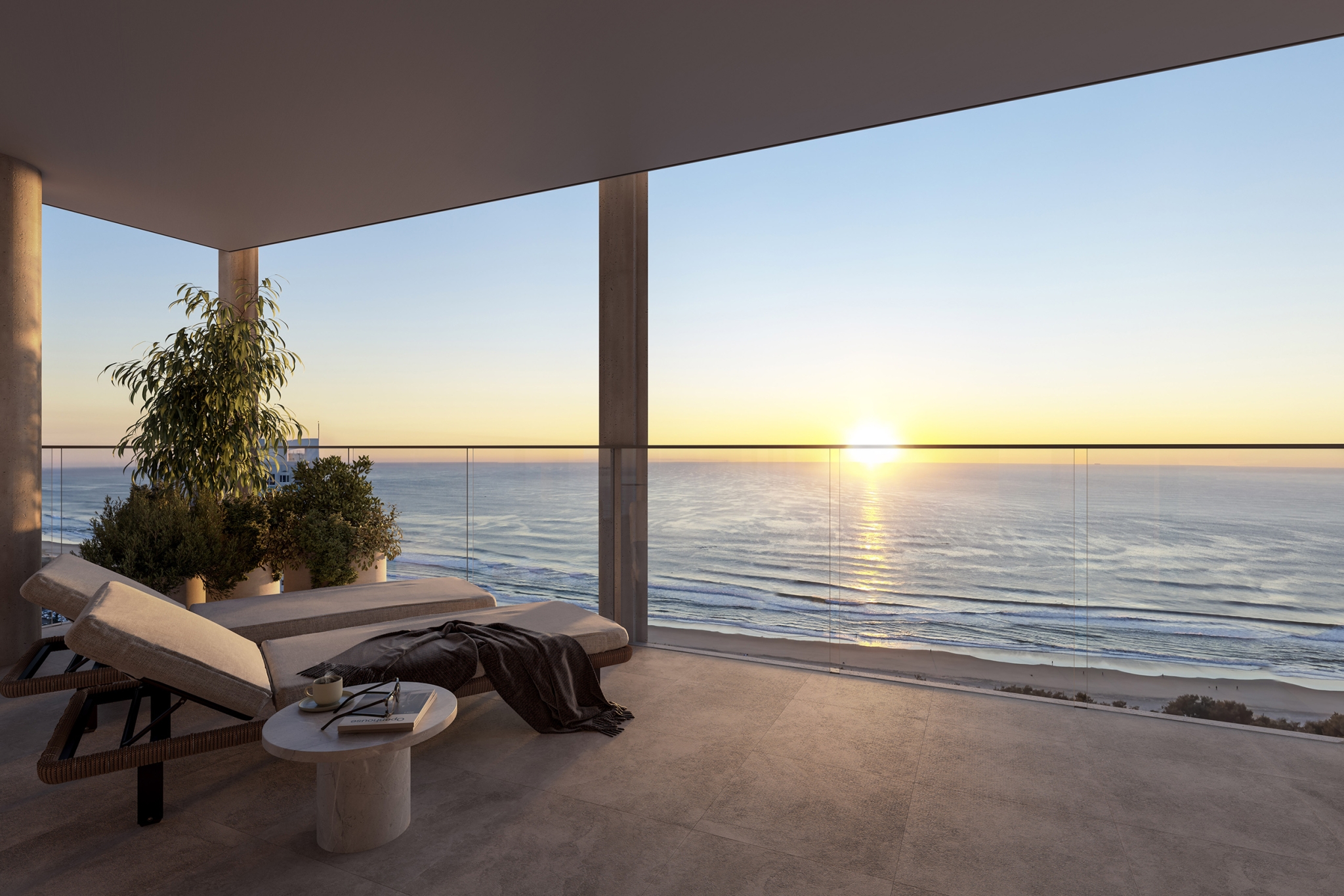 Balcony with two lounge chairs looking out to ocean with sunset